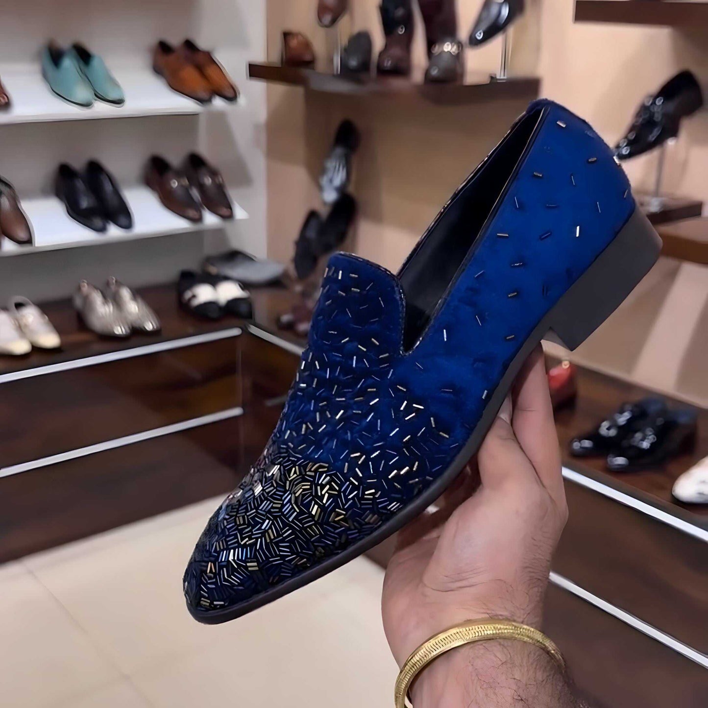 Blue Kardana embroidery moccasin shoe held in hand with shoe store background