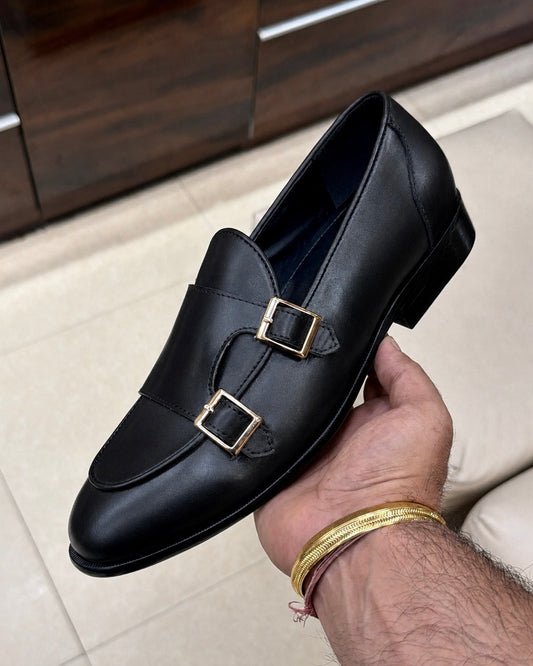 Black double monk strap loafers with gold buckles