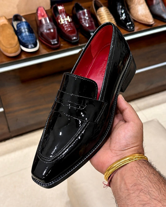 Black patent leather penny loafers with red lining